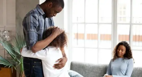 Family, mother and father, comforting their child with a hug