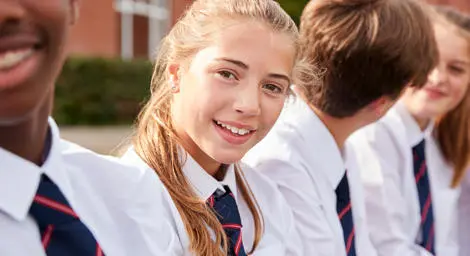 Teenage girl in school uniform smiling