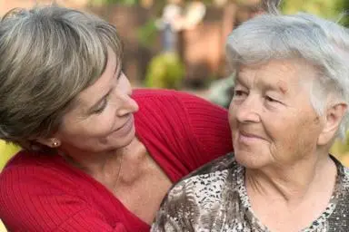 Younger woman looking affectionately at older woman