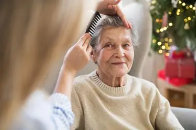 Younger woman combing older woman's hair