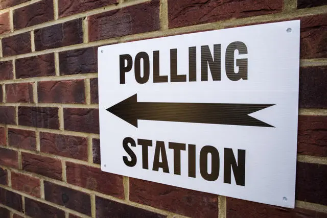 Polling station sign on brick wall