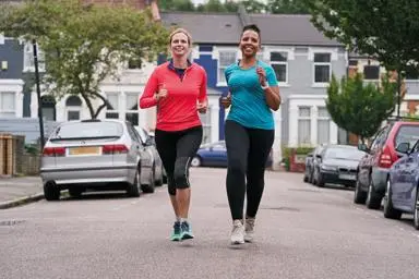 Two women going for a run on a street