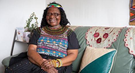 Black woman relaxing and sitting at home smiling
