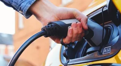 A yellow car charging at an EV chargepoint.