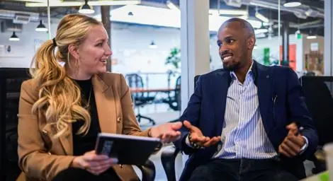 Business meeting between a man and woman holding a tablet