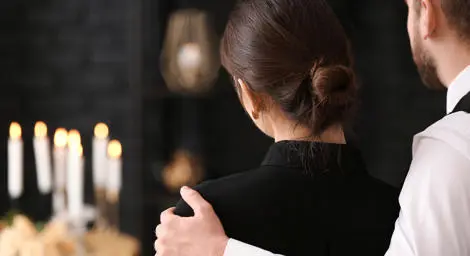 Man holding a woman at funeral