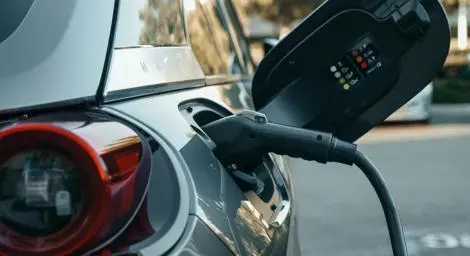 A close shot of an electric vehicle charger inserted into the vehicle.