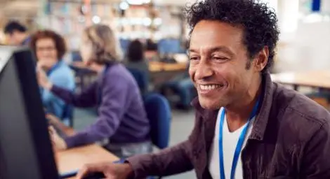 Man using computer wearing a landyard