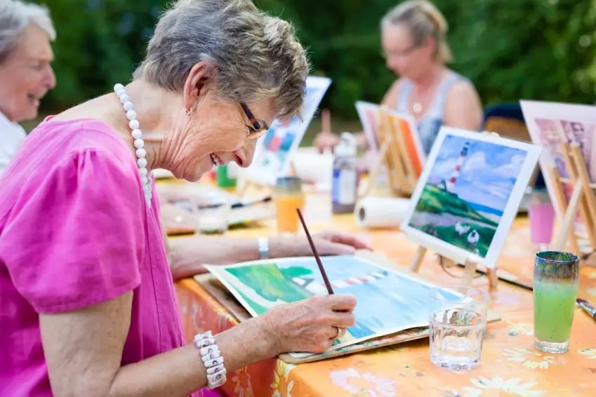 Smiling woman painting outside