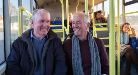 Two older men on a bus.