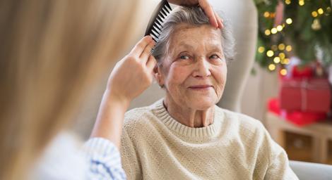 Younger woman combing older woman's hair