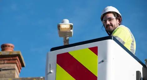 Man in high vis and hard hat on top of a crane