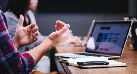 People in a meeting room looking at laptop