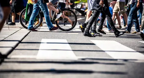 A group of people are walking across a zebra crossing
