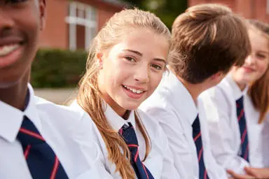 Teenage girl in school uniform smiling