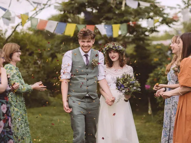 Bride and groom just married with confetti thrown at them.