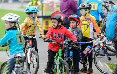 Five children in colourful clothes on bicycles taking a cycling course