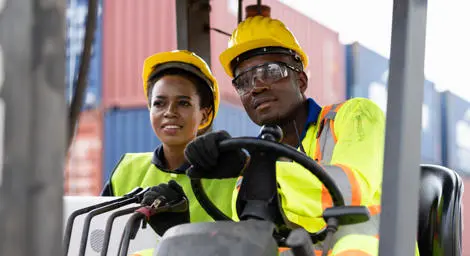 Man and women on a forklift truck at some docks